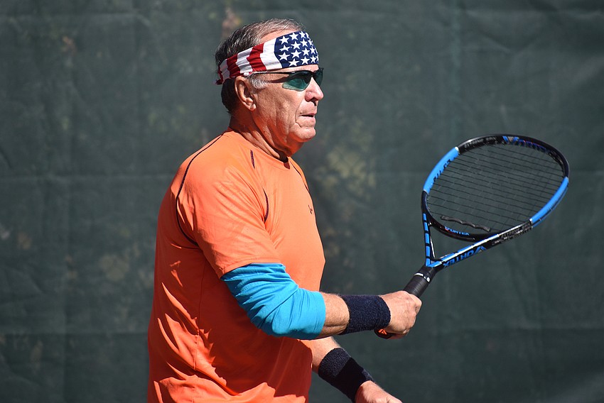 John Beeman watches the ball after he serves during a preliminary match.