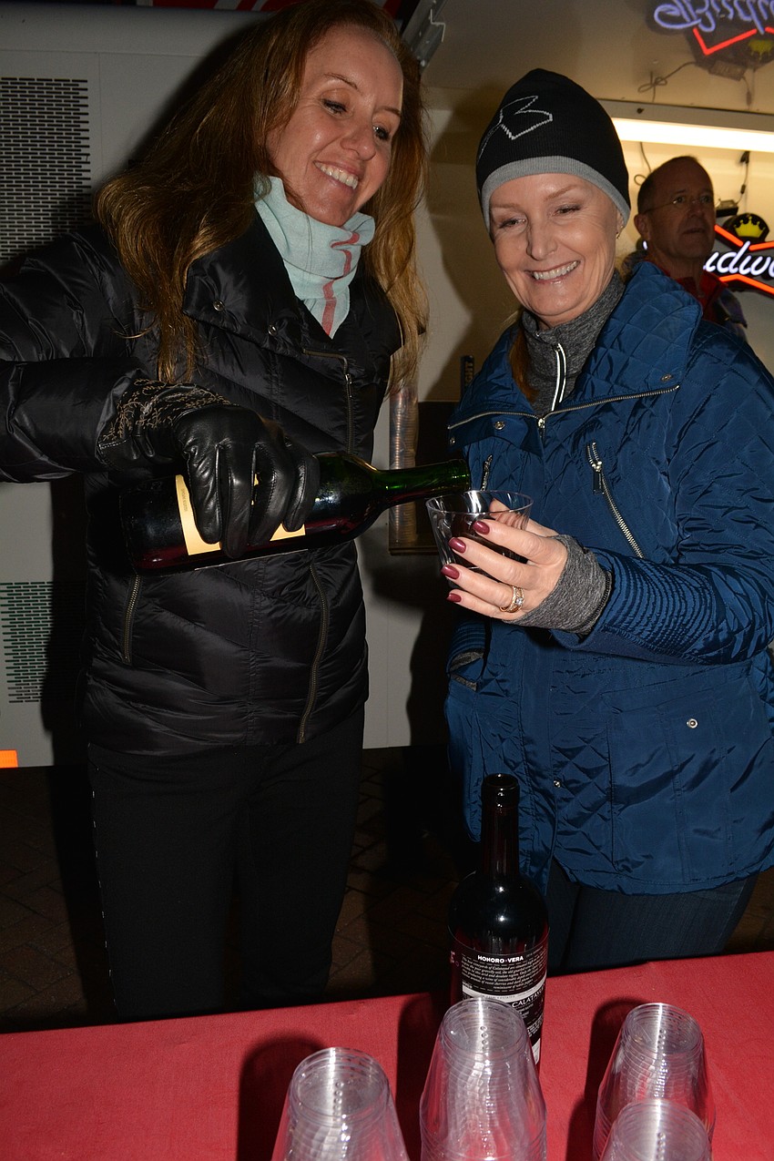 Cindy Cavallaro, of Sarasota, and Meg McDonnell, of Lakewood Ranch, pour beer and wine to guests.