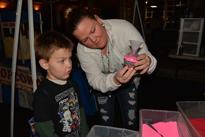 Sarasota's Valerie Glessing helps her 5-year-old son, Blake Swann, make sand art.