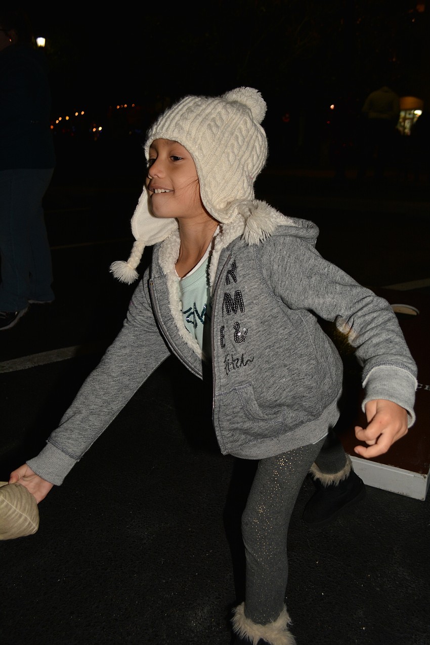 Ruskin's Lena Rodriguez, 6, tries her aim at a game of corn hole.