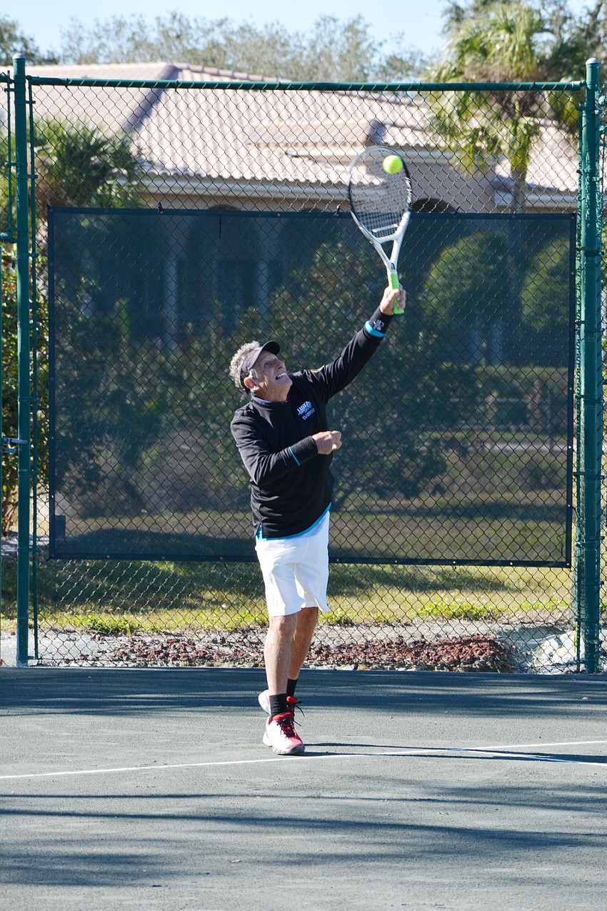 Enrique Vela serves up a point in the Division 2 mixed doubles match Sunday.