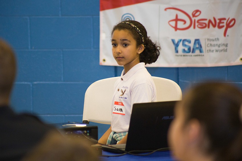 Sara, a club member ambassador, helps Maddy with her presentation by changing the PowerPoint slides for her.