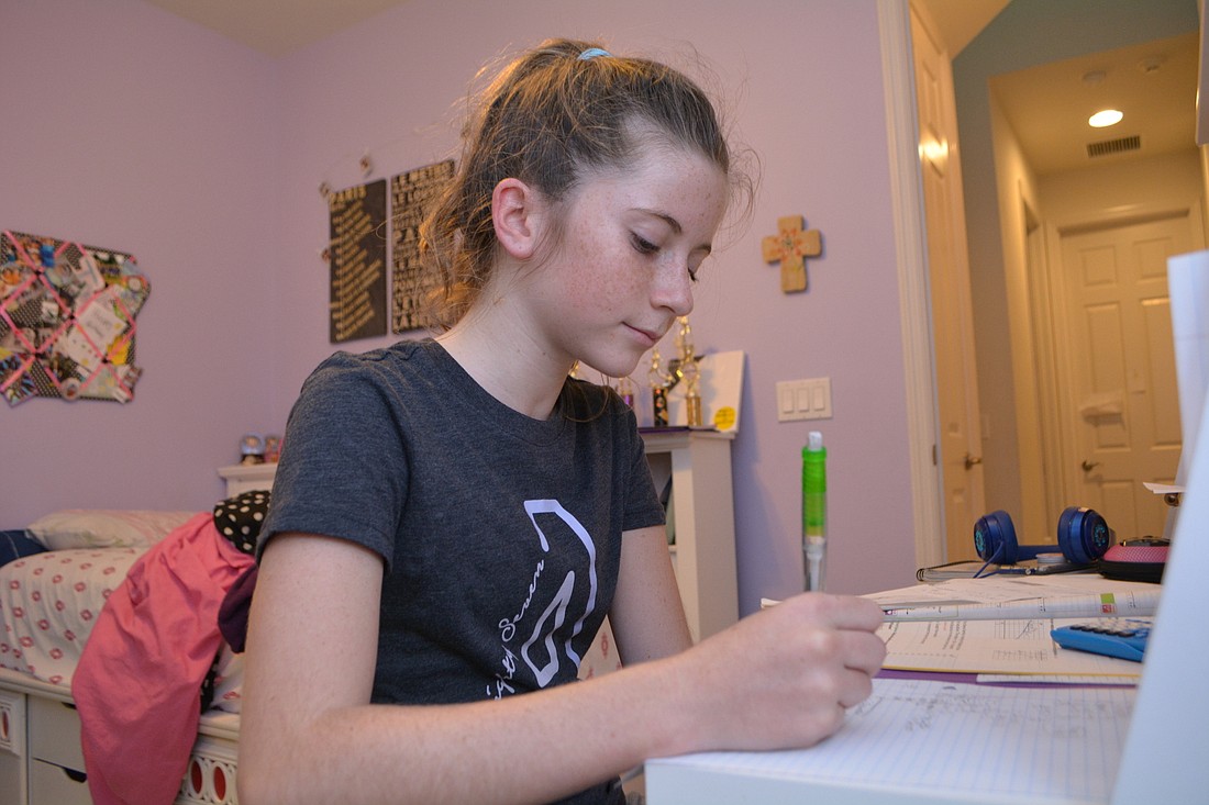 Josylyn Chapman, 12,  completes math homework at her GreyHawk Landing home. She likely will be redistricted to attend the North River High School when it opens.