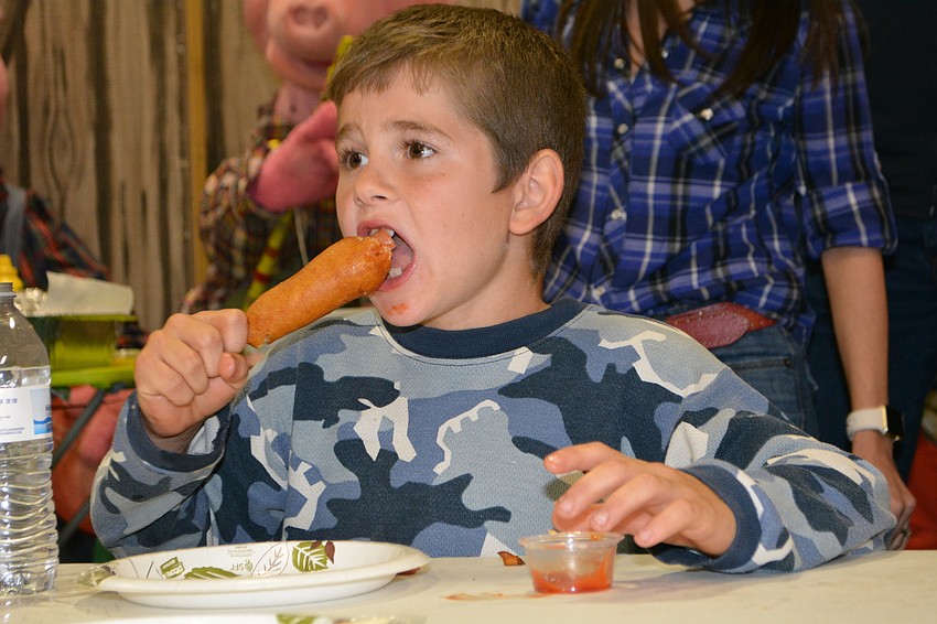 Myakka's Simeon, 7, can't stop smiling as he participates in the corn dog eating contest.