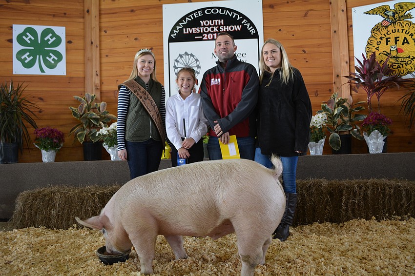 Manatee County Cattlemen Association Sweetheart Genaveve Henson poses with swine shower Natalie Greenhaw, of East County, the buyer of her pig, Alan Conley with Rhiannon Swirles.