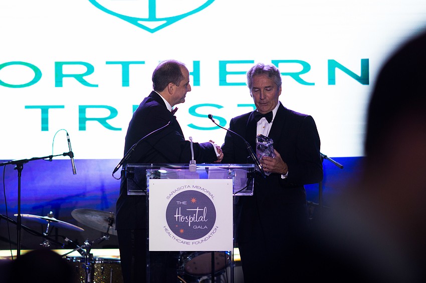 Sarasota Memorial Healthcare Foundation President Mason Ayres gives Phil Delaney, vice chairman of Florida Northern Trust, an award to thank the bank for its sponsorship.