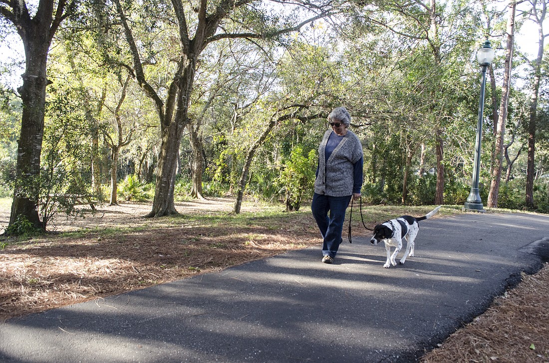 Anne Bryant and Georgia take a walk at Arlington Park, one of several city-owned, county-operated parks that may lose funding as Sarasota County considers how to reduce its budget.