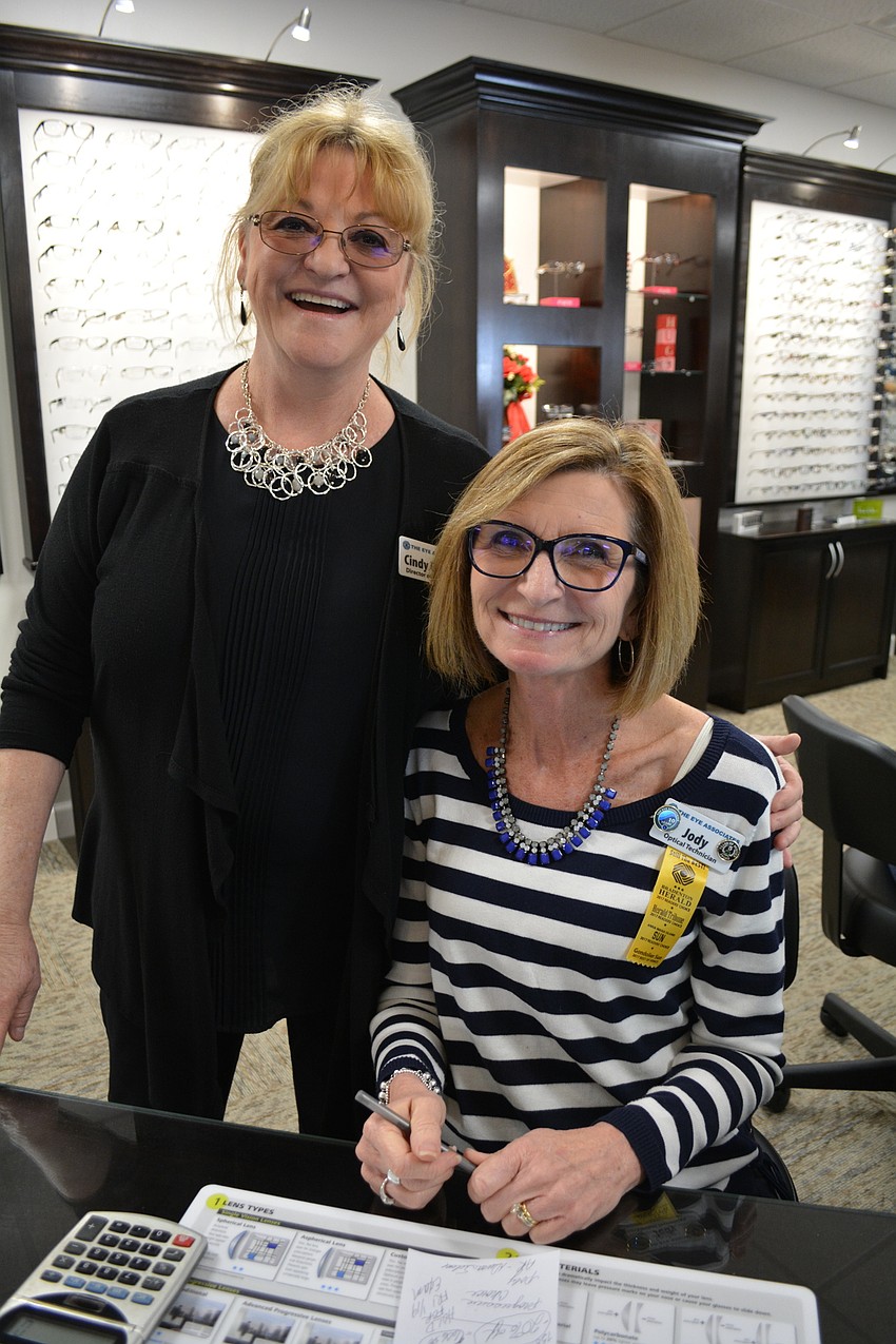 Marketing Director Cindy Baxter visits with optical technician Jody Miller.