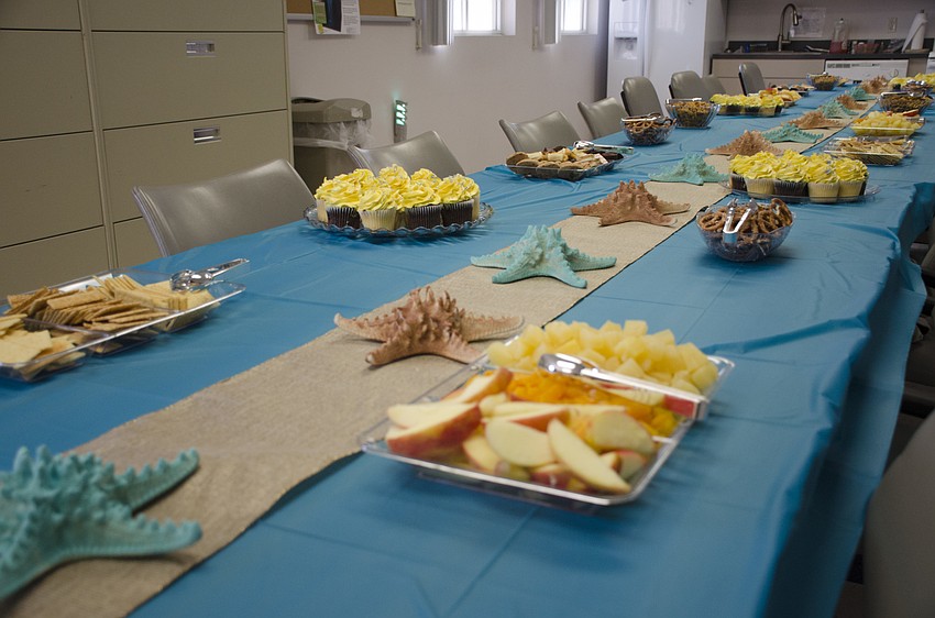 More than 20 attendees from the community snacked around the beach-themed table at Juan Florensa's going-away party.