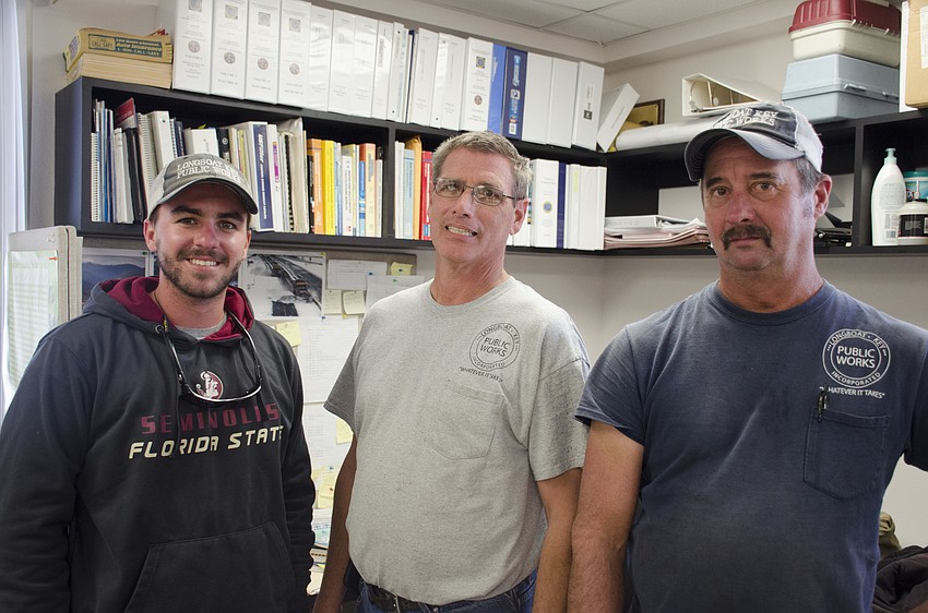 Public works employees Troy Wootan (left), Joe Samblanet and Lloyd Hine mulled in the back room while citizens socialized at Juan Florensa's going-away party.