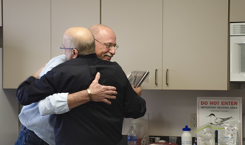 James Linkogle presented Juan Florensa with a laundry list of gifts, including a bag of sand, a industrial faucet head and, last but not least, a plaque and hug farewell.