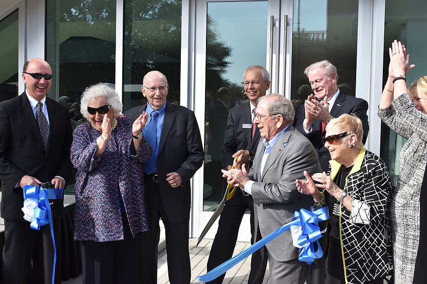 Mark Pritchett, Nancy and Phil Kotler, Steven High, Warren Coville, John Thraser, Margot Coville and Veronica Brady celebrate the ribbon cutting.