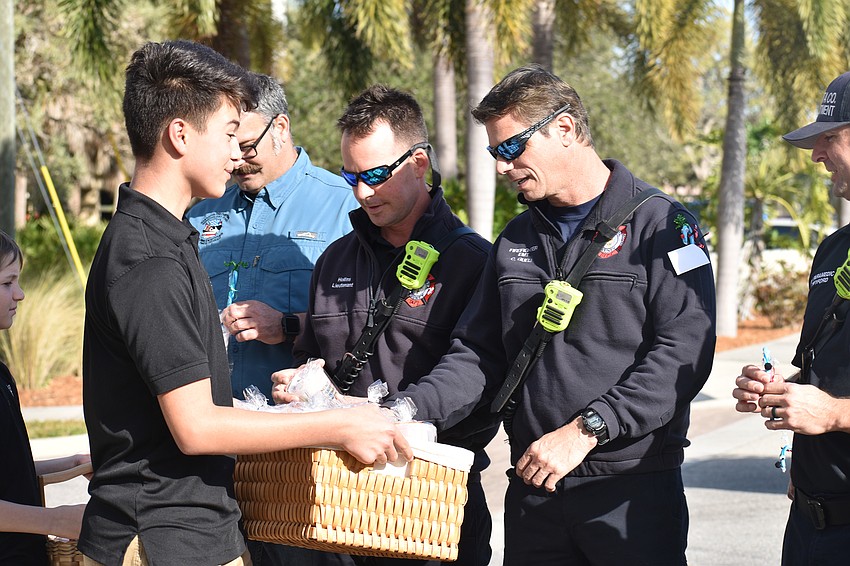 Darwin Rojas of Sarasota School of Arts and Sciences hands out candy to Sarasota firemen.