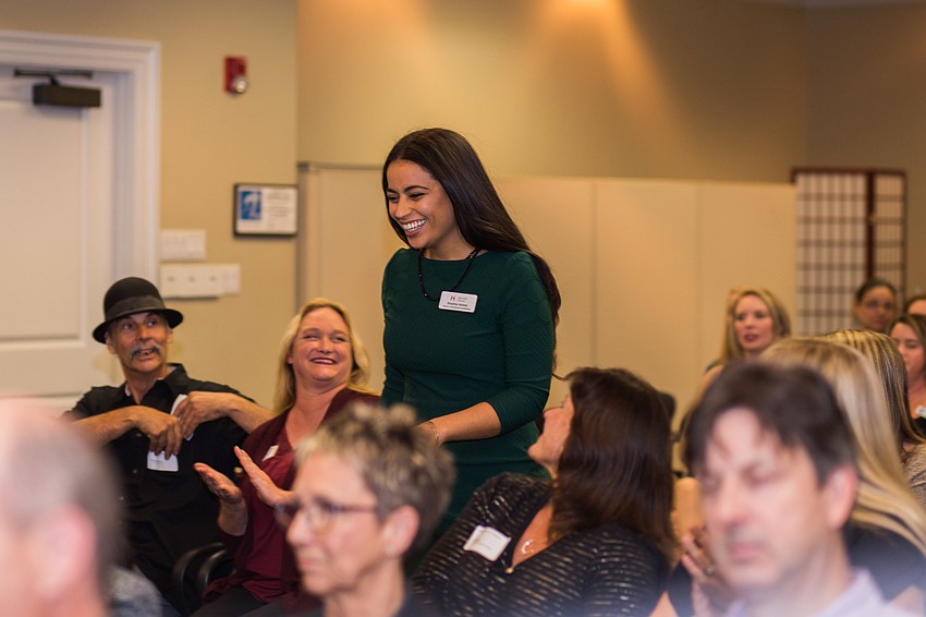 Shaelina Holmes skips to the front of the room to collect the check for Booker Middle School VPA.