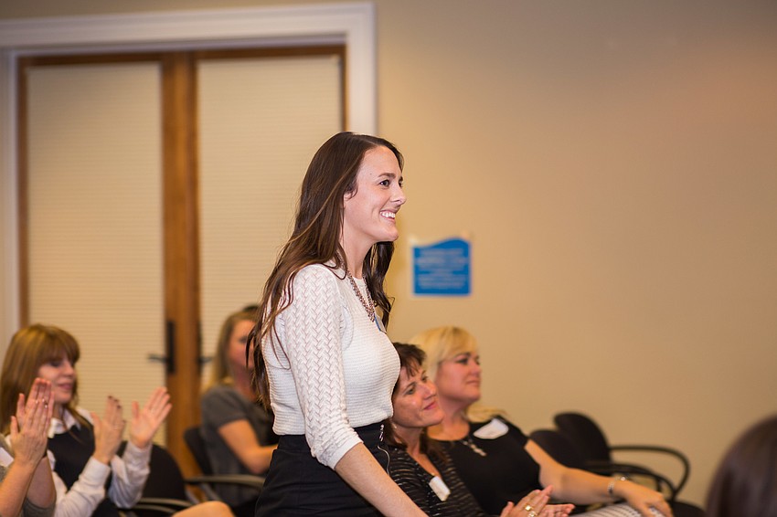 Sara Bealor walks to the front of the room to receive a check for the Boys & Girls Club of Sarasota.