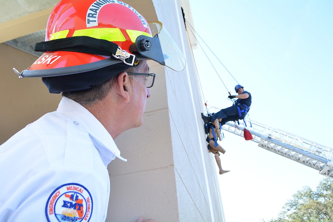 East Manatee Fire Rescue Training Officer Bob Mikulski watches firefighter Derek Parker perform a practice rescue. Mikulski is excited East Manatee can use the tower day or night.