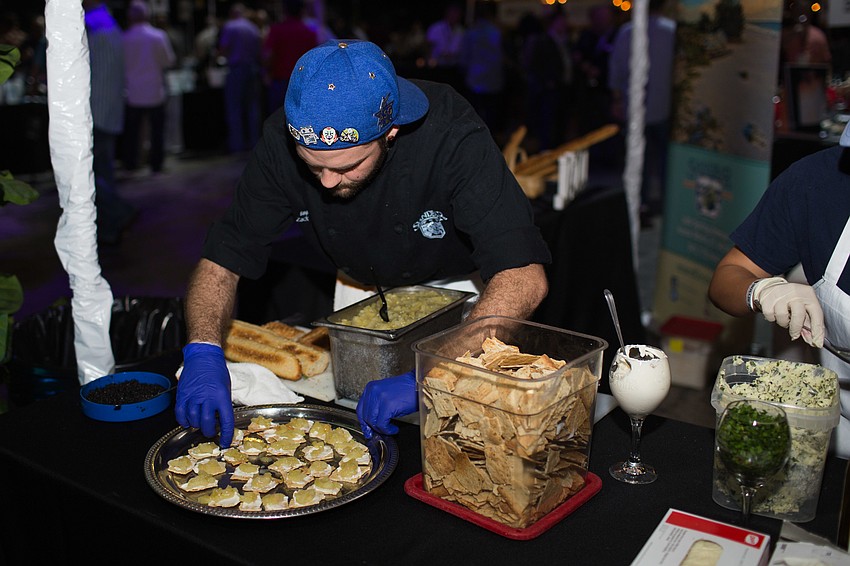 Zack Bozarth, a cook at the Sandbar Waterfront Restaurant, tops the hemp crackers with green tomato pie with caviar.