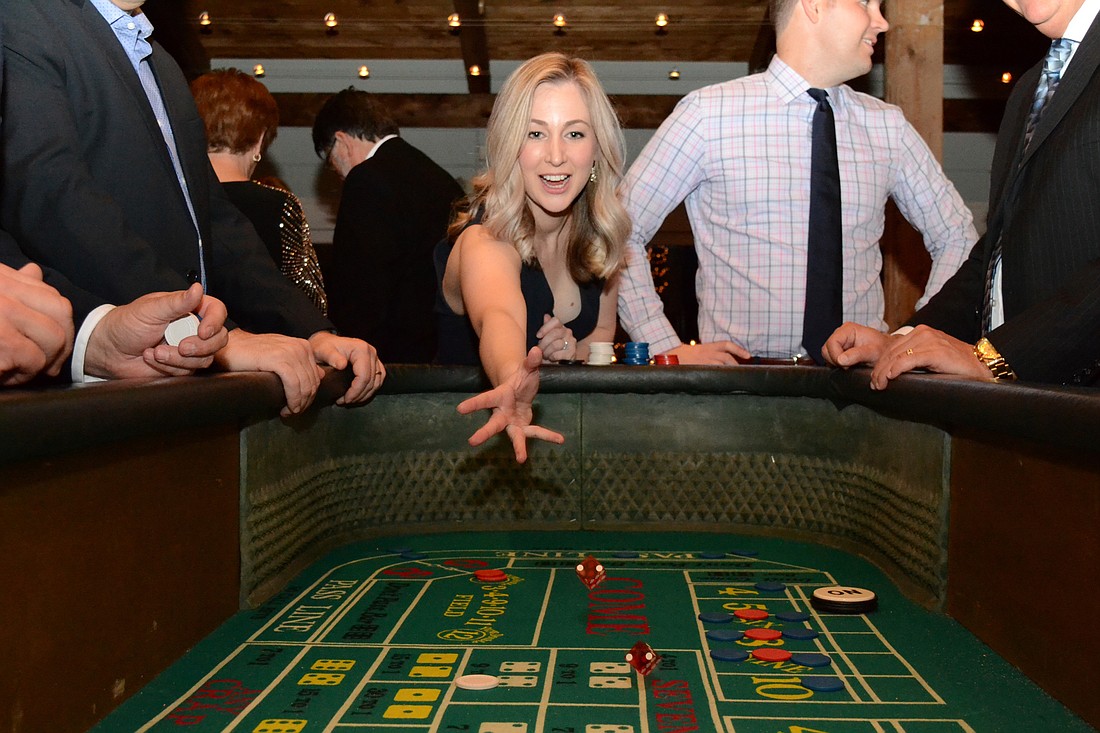 Amanda Tullidge plays craps at We Care Manatee&#39;s Rollinâ€™ on the River casino night.