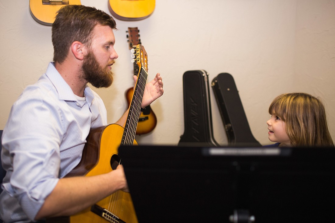 Zachary Johnson gives Isla, a Suzuki student, a guitar lesson. Photo by Kayleigh Omang