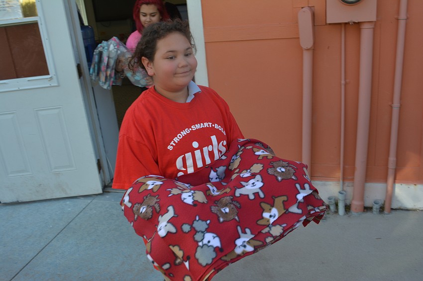 Morgan Mock, 11, carries out a blanket to be presented to Nate's.