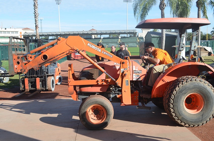 Head Groundskeeper Dan Thomas helps remove containers carrying the team's bats, ball and other gear from the moving van.