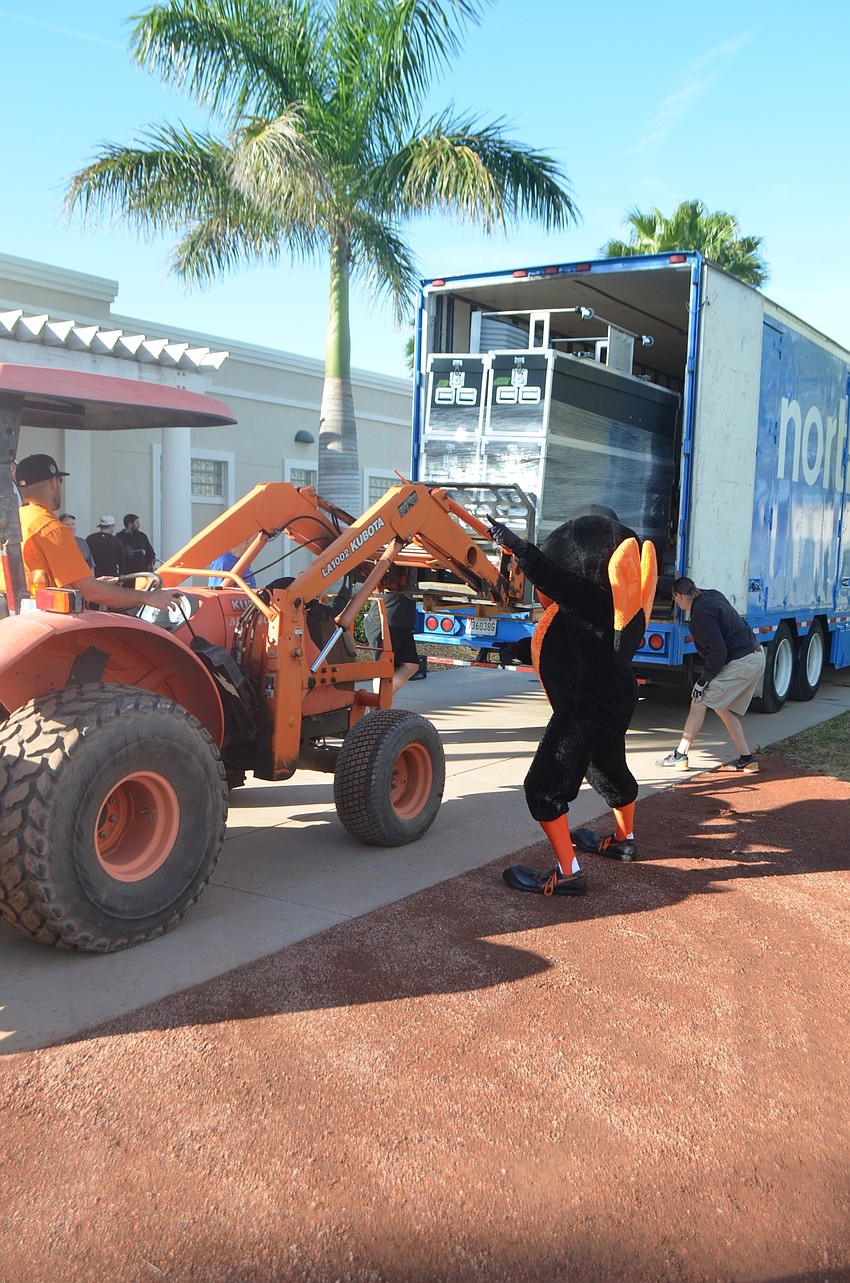 The Oriole Bird helps direct team staffers unloading equipment.