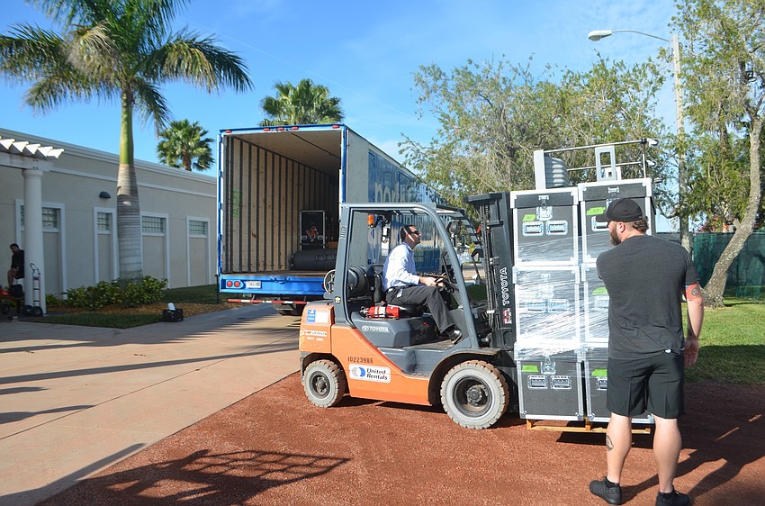 Trevor Markham, director of operations for Orioles-Sarasota, uses a forklift to carry team gear into Ed Smith Stadium.