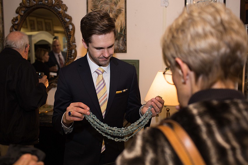 Ian Klopfer pulls out an aquamarine bead necklace.