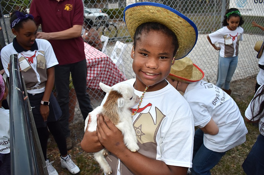 Club member Makaley gets to know a baby goat in the petting zoo.