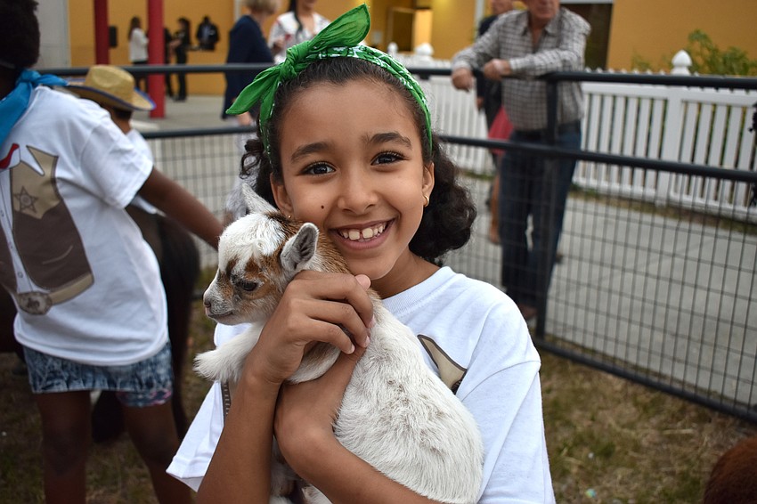 Club member Sara gives a baby goat a hug in the petting zoo.