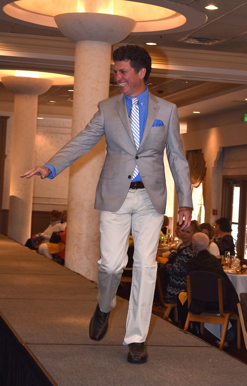 Lee Mirman waves to the crowd as he walks the runway.