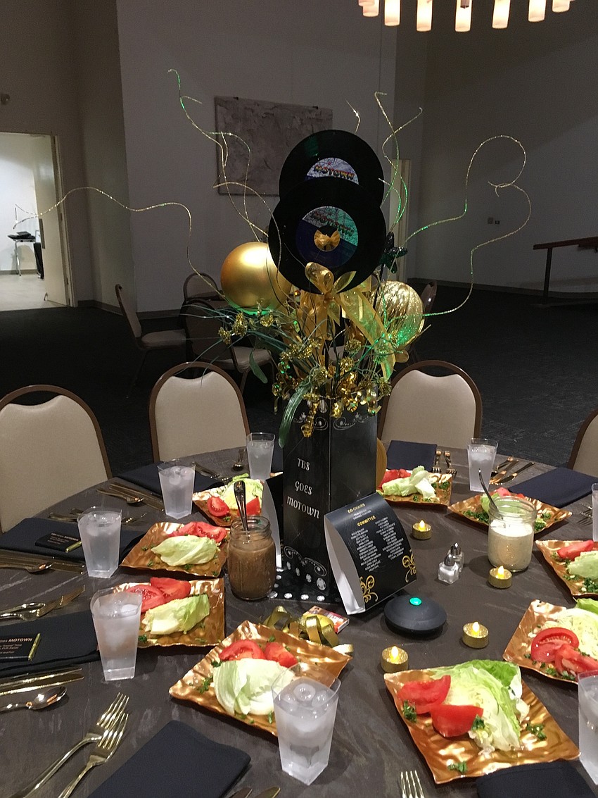 The tables were decorated with a centerpiece featuring records and gold decor.