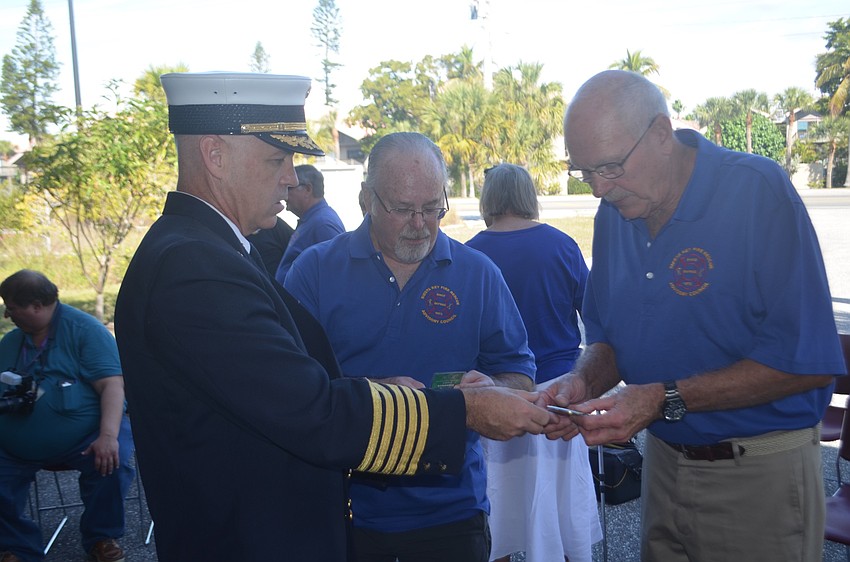 Frank Jurenka (right) and Ray Donnelly (center) receive challenge coins from Michael Regnier.