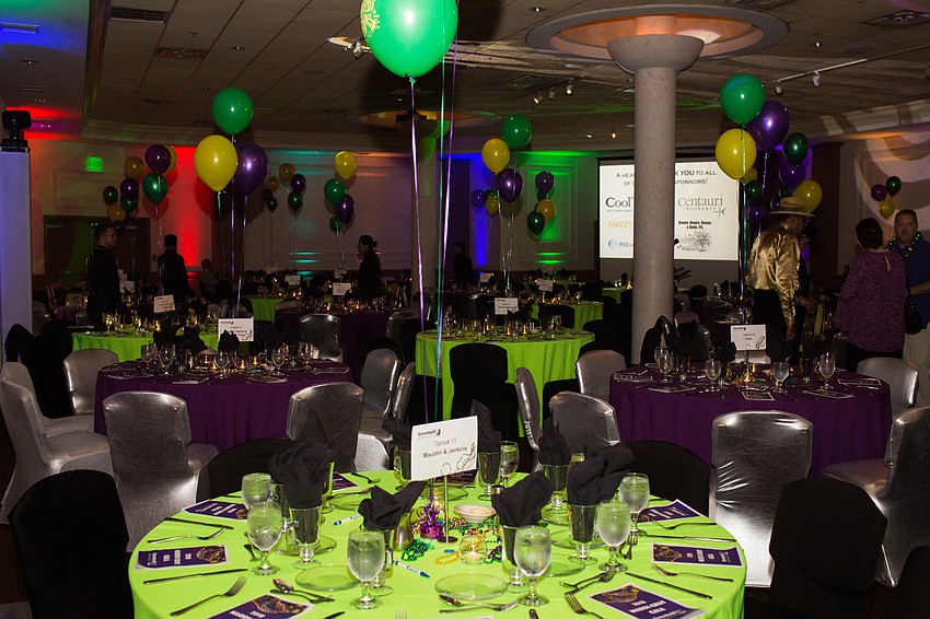 The room was colorful with balloons and multicolored lights among the green and purple tables.