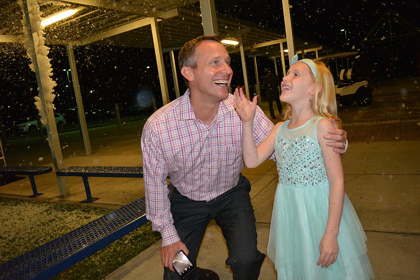 Russell and Julia Pygott enjoy grabbing snow flurries on their way into the dance.
