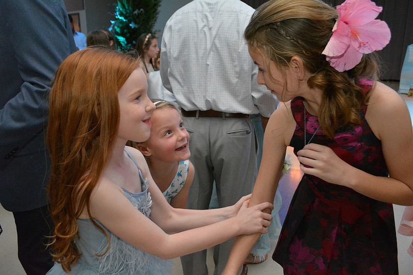 Emerson Avery, front, and Meredith Organek, behind, wish Delaney Wilson a happy 11th birthday after the disc jockey had attendees sing 