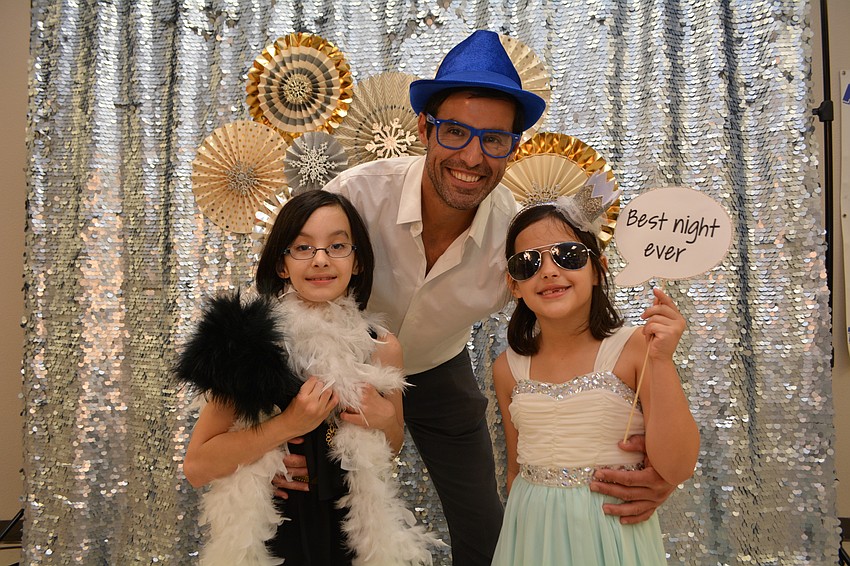 Alvaro Blanco poses with his daugthers Valentina, left, and Lucia, right, for a photo to go on a handmade picture frame.