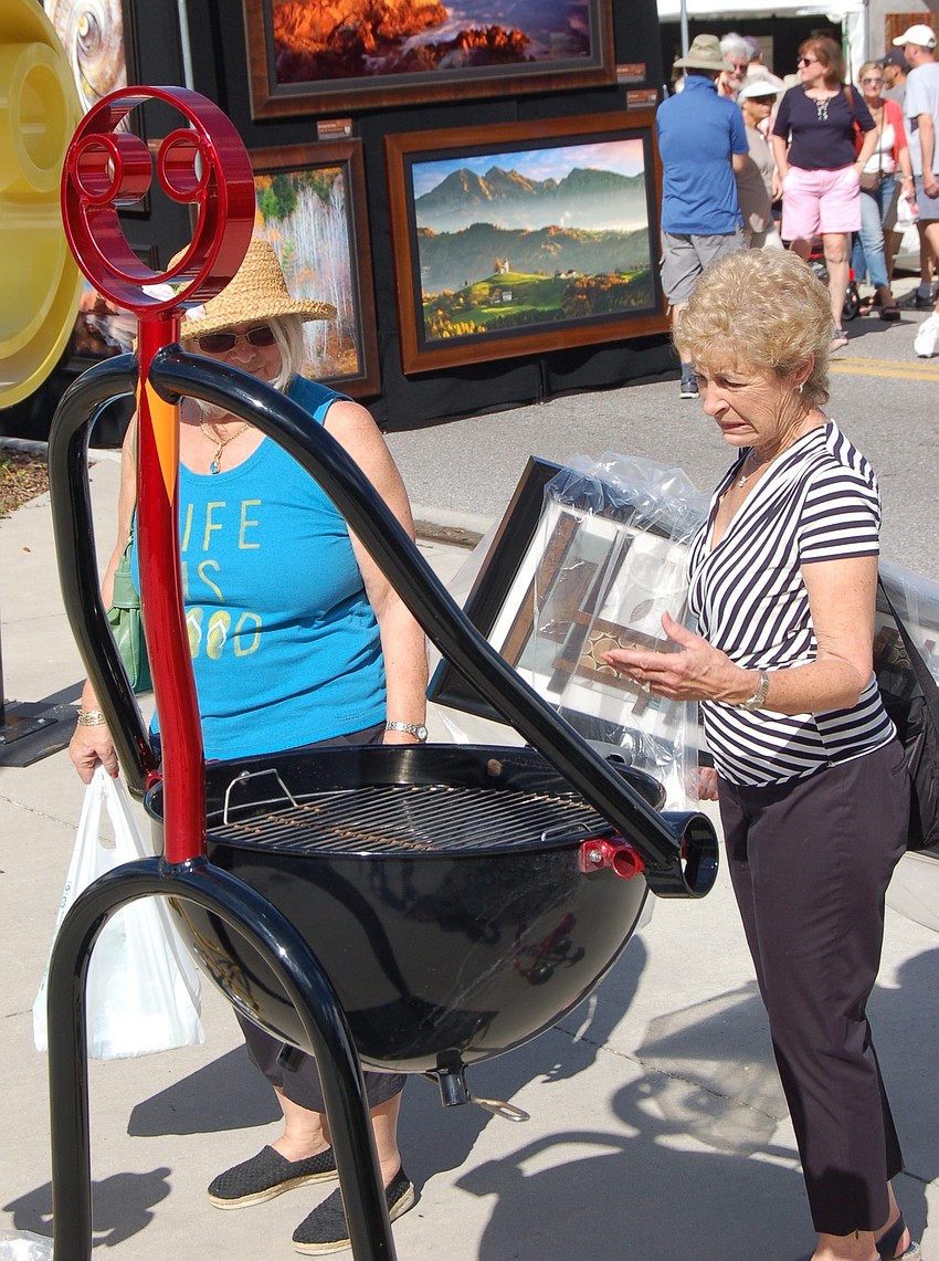 Marianne Jean, left, and Melanie Kraft stopped to check out the Tube Dude's barbecue grill creation.