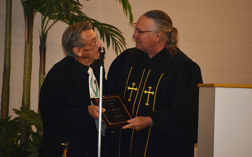 The Rev. Bill Friederich presents a plaque to Al Hixon for his 25 years of Jazz Sunday performances.