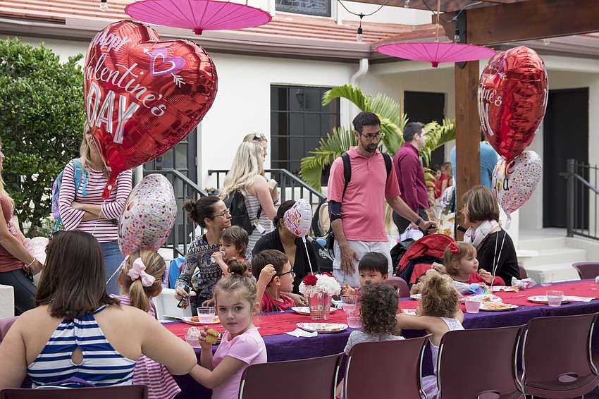 Preschoolers and their families gather in the school's courtyard, which was transformed into a Valentines Day wonderland.