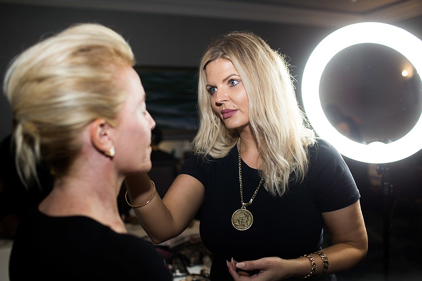 Kamila Wysocka of Makeup SRQ applies eye makeup to a model.