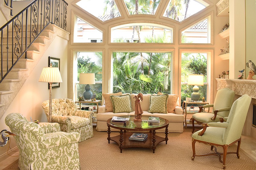 Across from the formal dining room, a green-accented living room lets in natural light.