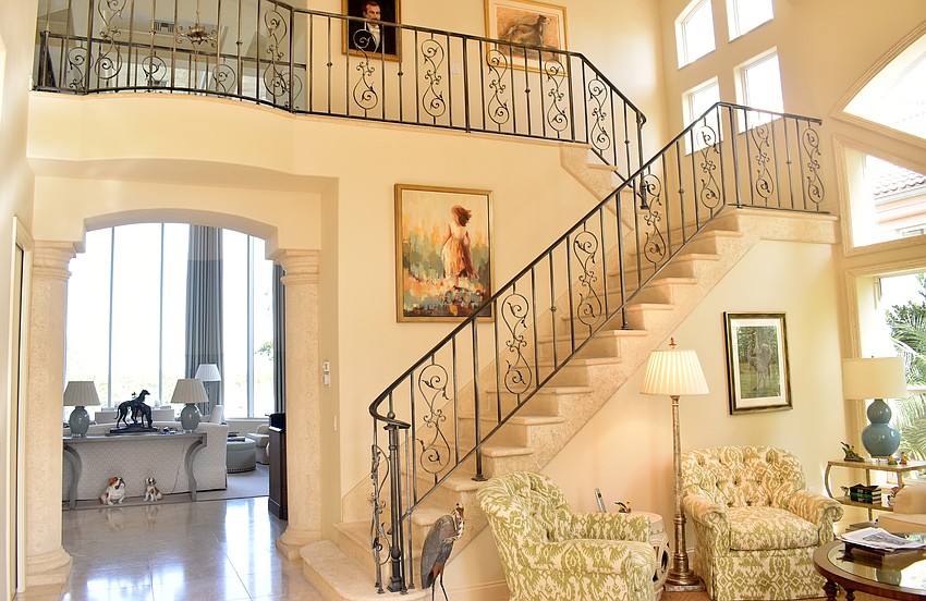 A wrought-iron railing and stone stairs lead upstairs to two more rooms and a full bathroom.