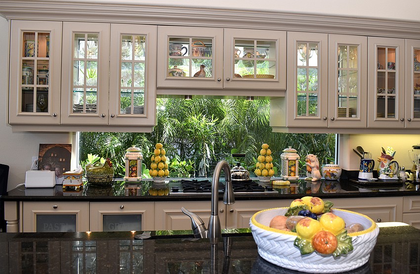 Above dark, granite counters are cabinets with glass backs letting natural light into the kitchen.