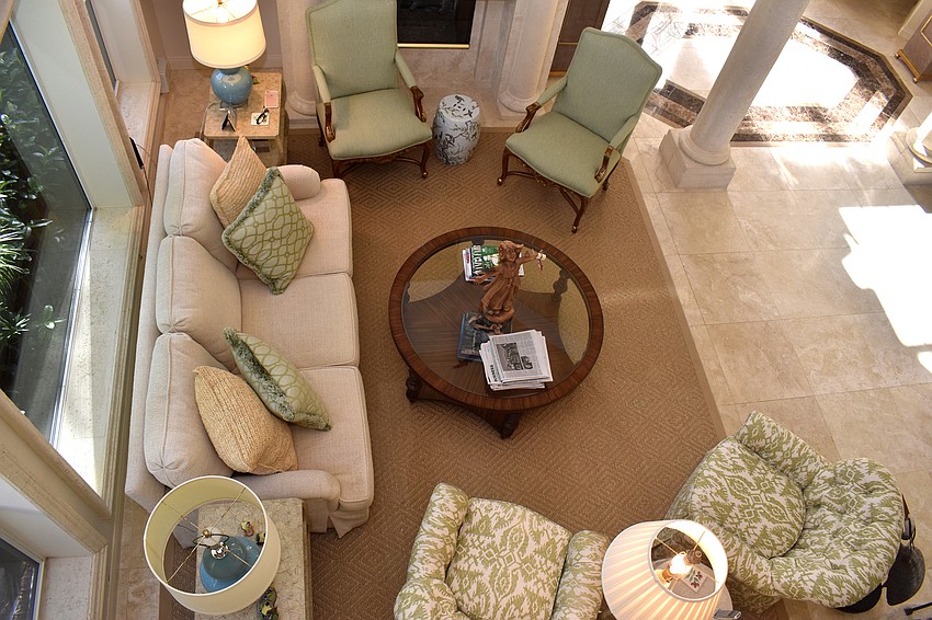 A downward look from the grand staircase shows the seating arrangements in the living room, which is complete with a fireplace.
