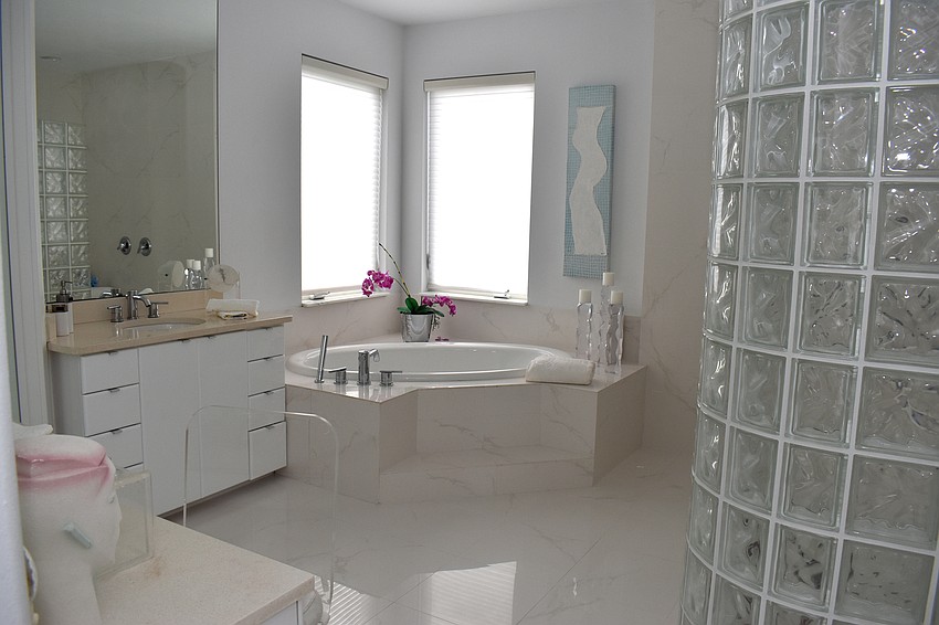 His and her sinks, a large bathtub and walk-in shower make up the master bathroom.