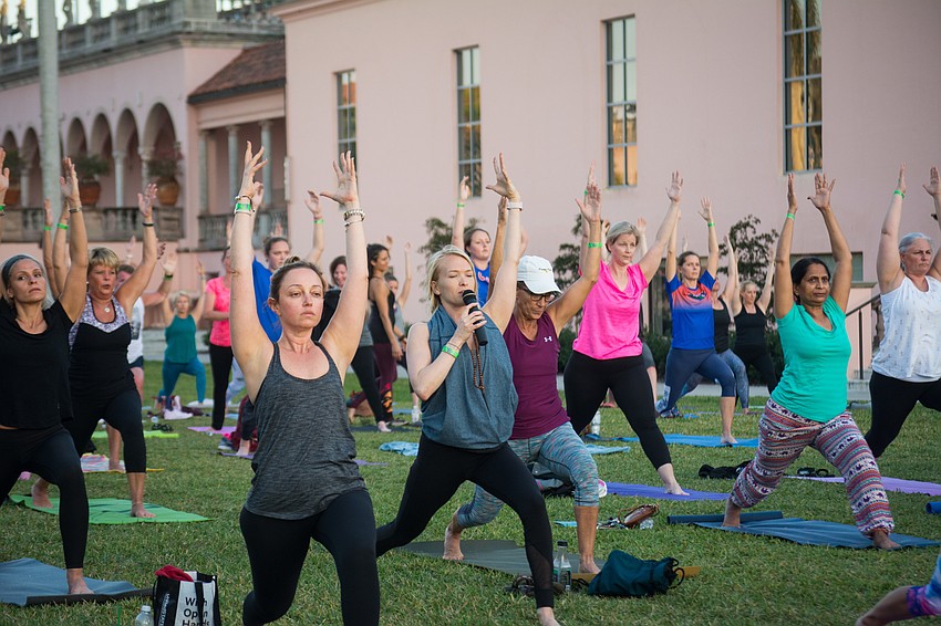 With a microphone in hand, Ashley Stewart from Yoga Mind and Body leads yogis through their practice