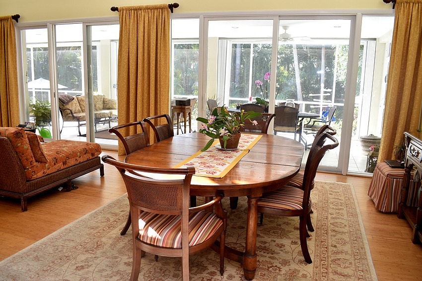 A dining room table takes up the right side of the open living area overlooking the pool and backyard.