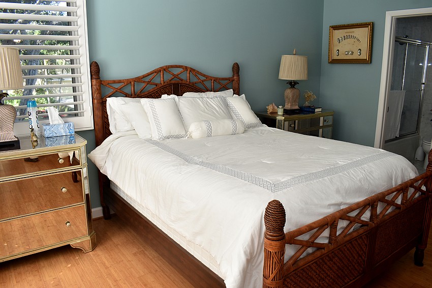 A guest bedroom gives off a tropical vibe with blue walls.