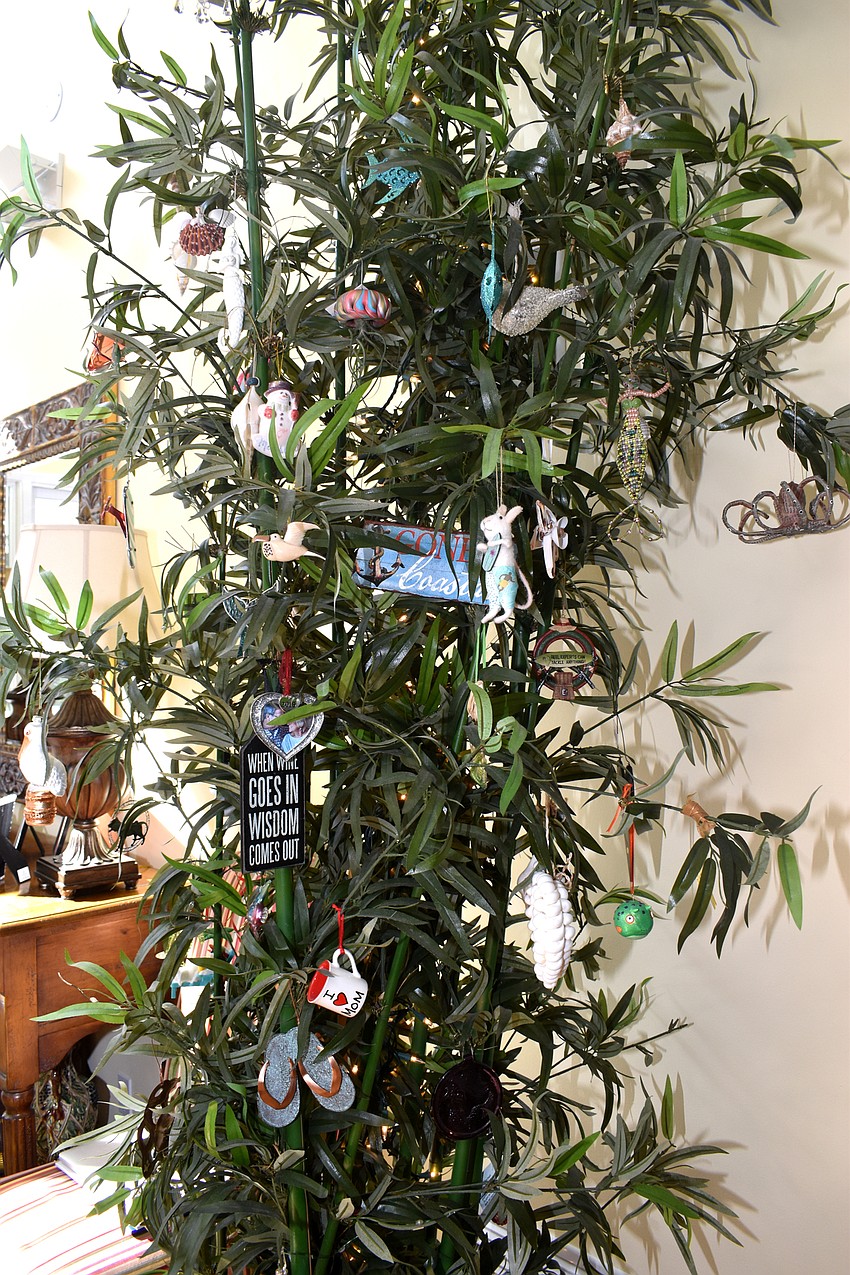 Claudia Hennigan has a ficus plant in her living room that guests decorate with ornaments from their visit.